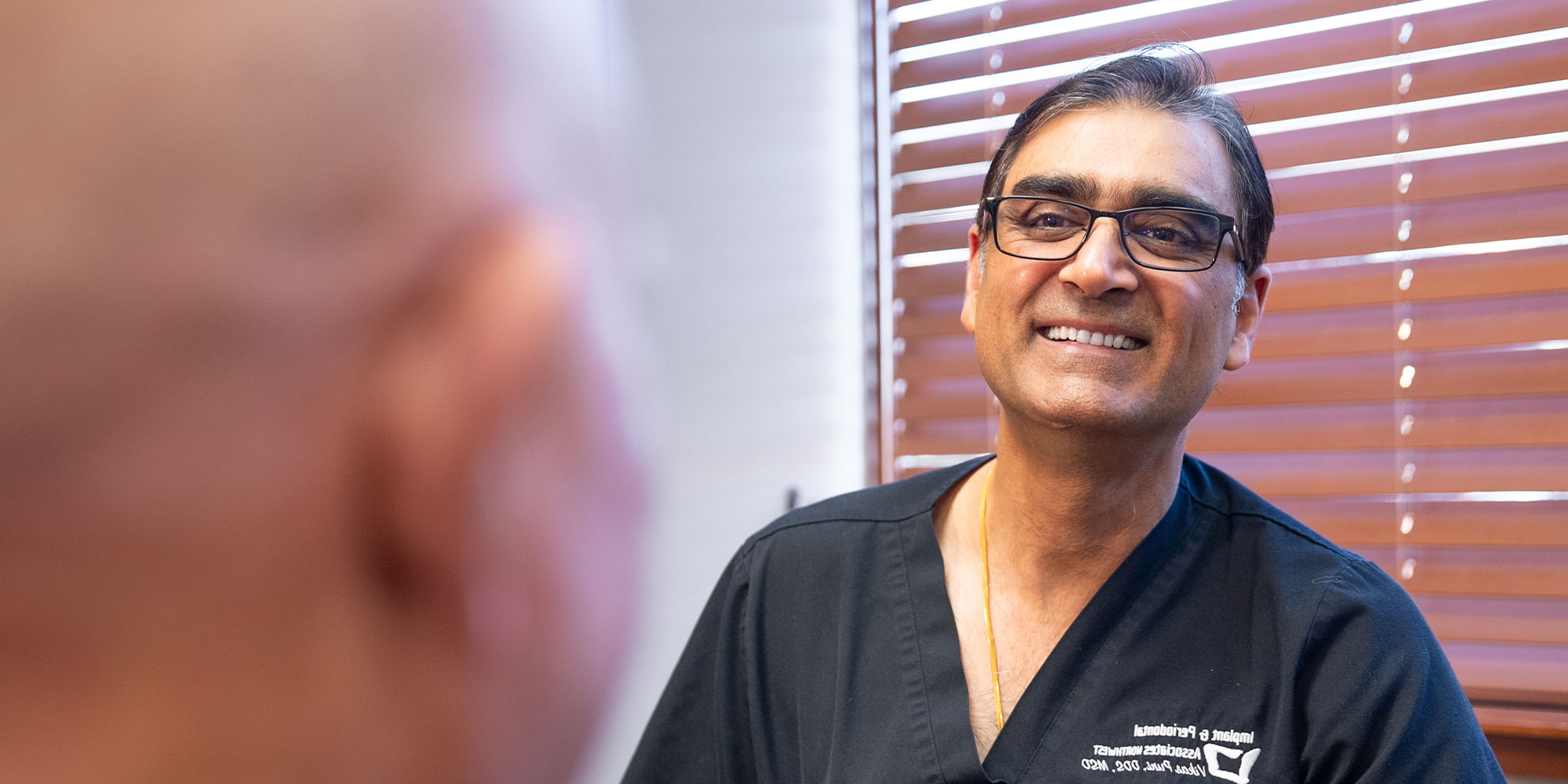 docto smiling and going over dental procedure information with patient