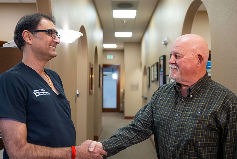 patient and doctor shaking hands within the dental center after dental procedure