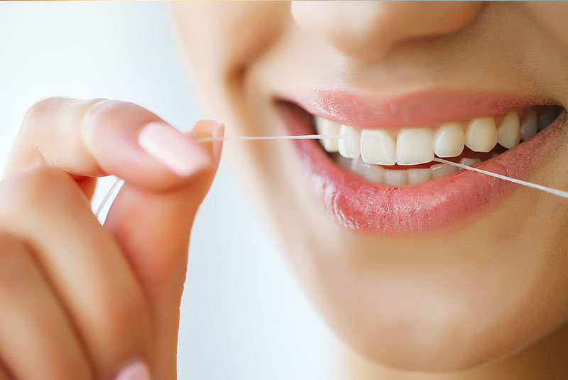 Smiling dentist holding dental tools