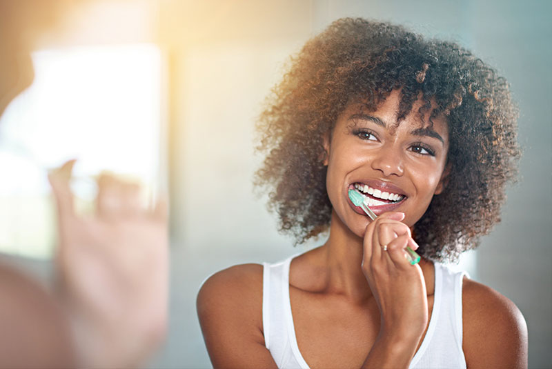 person brushing their teeth in their bathroom